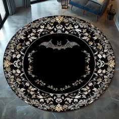 a black and gold round rug with bats on it in the middle of a living room