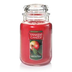 a red yankee candle with an apple on it