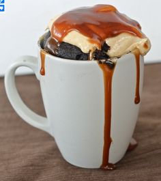 a cup filled with ice cream and caramel drizzled on top of it