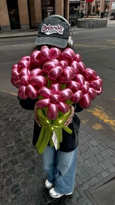 a person holding a bunch of balloons on the street