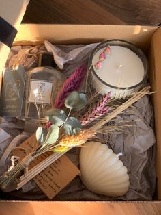 an open box containing candles, flowers and other items