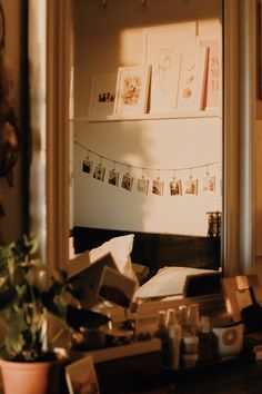 a room with boxes and pictures hanging on the wall next to a potted plant