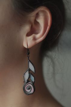 a close up of a person's ear wearing some kind of earrings with designs on it