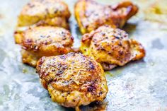 four pieces of chicken sitting on top of a pan