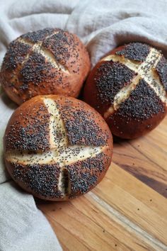 three loaves of bread sitting on top of a wooden cutting board with the words vegan pretzel buns recipe