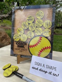 a table with a sign and some baseballs on it