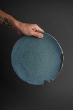 a person's hand is holding a blue plate