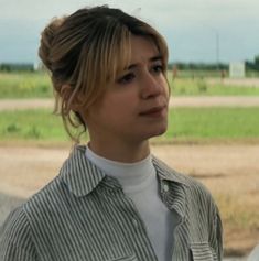 a woman standing in front of an open field