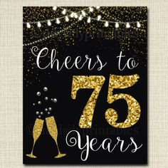 cheers to 75 years sign with gold glitter and champagne glasses on black paper, hanging from string lights