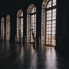 an empty room with many windows and statues