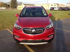 the front end of a red car parked in a parking lot