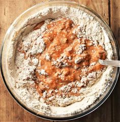 a bowl filled with powdered sugar and some type of meat sauce on top of a wooden table