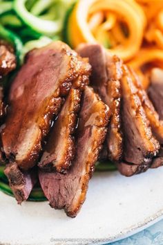 sliced meat and vegetables on a white plate