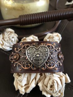 a brown leather wallet sitting on top of a table next to flowers and a candle