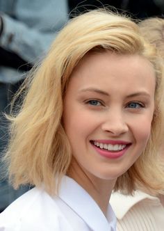 a woman with blonde hair smiling at the camera