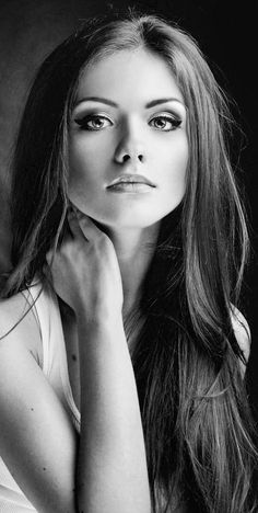 a woman with long hair posing for a black and white photo