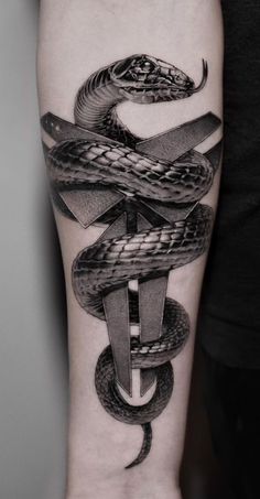 a black and white tattoo with a snake on the arm