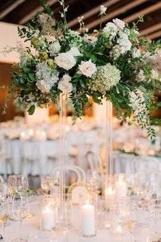 the centerpieces are filled with white flowers and greenery