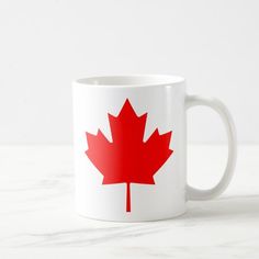 a white coffee mug with a red maple leaf on it