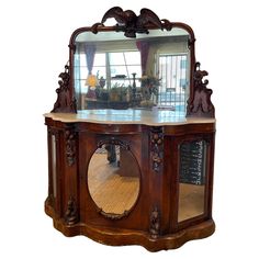 an ornate wooden cabinet with mirror on top