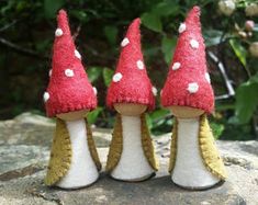 three small red and white mushrooms sitting on top of green moss