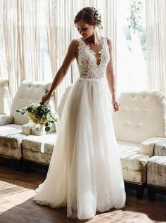 a woman standing in front of a couch wearing a wedding dress