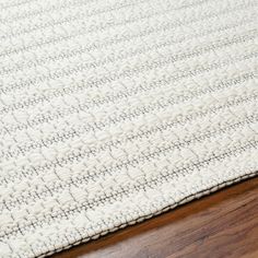 a white rug on top of a wooden floor