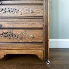 a wooden dresser with three drawers on wheels