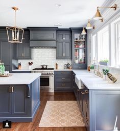 a kitchen with gray cabinets and white counter tops