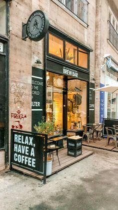 the outside of a coffee shop with tables and chairs