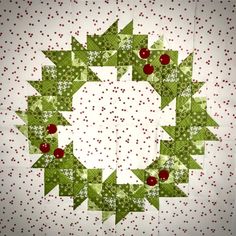 a quilted christmas wreath with red berries and green leaves on the center, surrounded by white polka dots