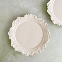 two white plates sitting on top of a table