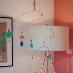 a lamp that is on top of a table next to a painting and some beads