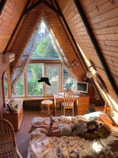 a woman laying on top of a bed in a bedroom under a slanted ceiling