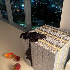 stacks of money sitting on top of each other in front of a pair of shoes