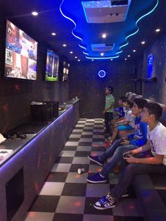 a group of young men sitting on top of a checkered floor next to each other