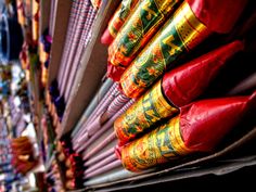 many colorful umbrellas are lined up on the shelf in front of eachother