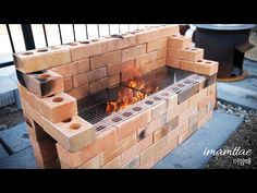 a fire pit made out of bricks with flames coming out of the top and sides