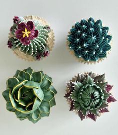 four cupcakes with flowers on them sitting next to each other in the shape of succulents