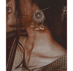 a close up of a woman's neck wearing ear rings and earrings with pearls