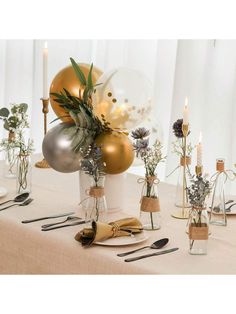 a table topped with vases filled with flowers and balloons