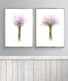 two framed pictures with flowers in them on the wall