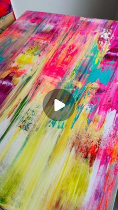 an abstract painting is being worked on by someone using paintbrushes to make it look like