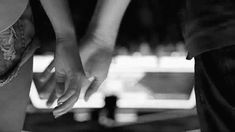 black and white photograph of two people holding hands with one person's arm around the other