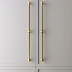 two gold handles on white cabinets in a room