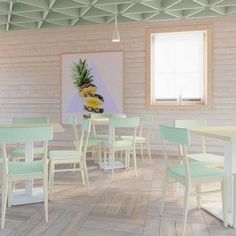 an empty restaurant with pastel green and white chairs, pineapple painting on the wall