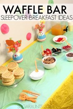 a table topped with waffles and other food items on top of a green table cloth