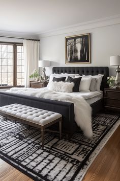 a large bed sitting on top of a black and white rug next to a window