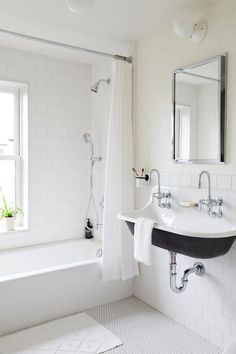 a bathroom with a sink, mirror and bathtub next to a window in it