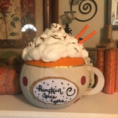 a pumpkin mug with whipped cream on top